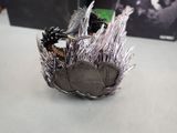 a metal bowl with a bird on it on a table