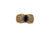 a close up of a gold ring with a black stone