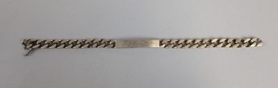 gros plan d'un bracelet en argent sur une surface blanche