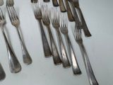a lot of forks and spoons that are on the table