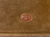 an image of a brown leather wallet with a coin on top of it