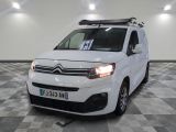 la camionnette blanche est garée dans une grande pièce au sol en damier