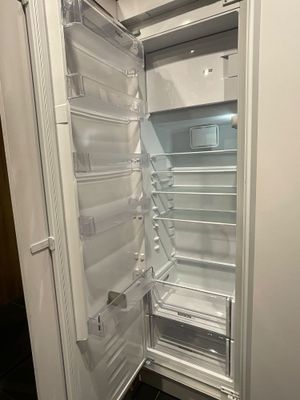 un réfrigérateur blanc dont la porte est ouverte, dans une cuisine