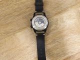 black leather strap on a watch on a wooden surface