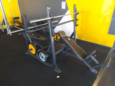 une salle de sport avec un banc, des poids et d'autres équipements