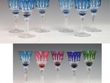 plusieurs verres à vin de différentes couleurs posés les uns à côté des autres sur une table