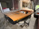 a boat that is sitting in a garage next to a car