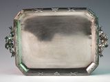 an antique silver tray with flowers and leaves on it