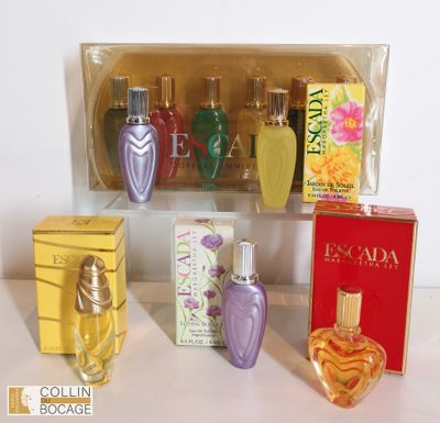 cinq flacons de parfum dans une vitrine posée sur une table