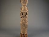 une vieille statue en bois représentant une femme avec un oiseau sur l'épaule