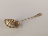 une cuillère en or ornée d'un coquillage