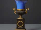 un vase bleu posé sur un socle en bois