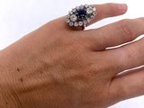 la main d'une femme tenant une bague sertie d'un diamant et d'un saphir