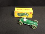 an old green toy car sitting next to a boxed box