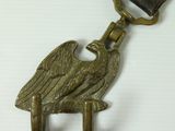 brass eagle keychain on a white background with a brown leather strap