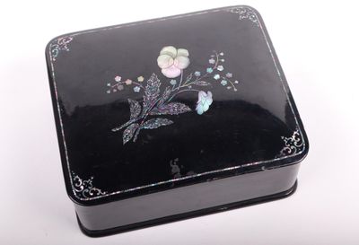 une petite boîte noire ornée d'un motif floral