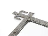 a metal cross that is on a white surface