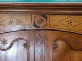 a wooden armoire with a clock on top of it