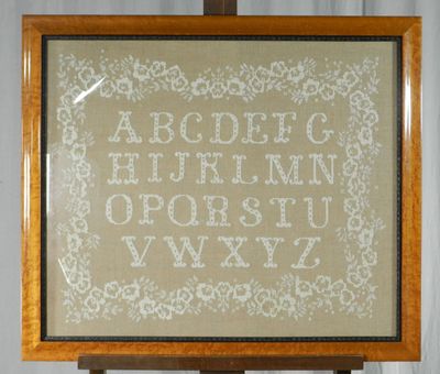 a picture of a cross stitched alphabet on a easel