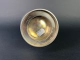 an antique silver cup with a label on it