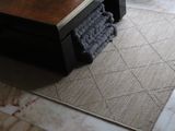 a rug on the floor next to a coffee table in a living room