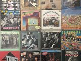several albums of various music are displayed on a wall