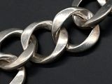a close up of a silver chain on a black surface