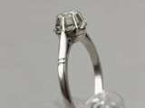 a close up photo of a diamond ring on a clear surface