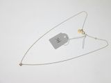 a silver necklace with a tag on it next to a pair of scissors and a pair of scissors