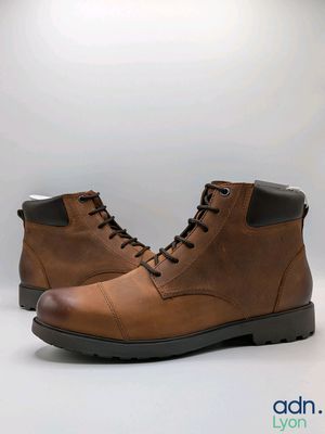 bottes en cuir marron pour homme, à semelles noires, sur fond blanc