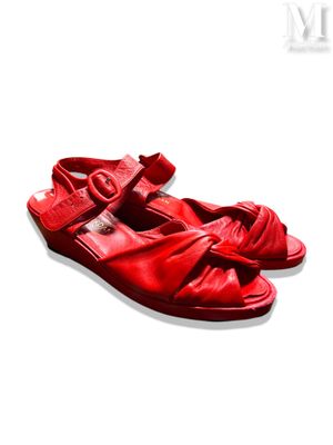 des sandales en cuir rouge posées sur une surface blanche, sur fond blanc