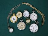 de nombreux modèles différents de montres de poche posés sur un fond vert