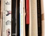many books in a cardboard box on a white surface