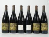 six bouteilles de vin sont alignées sur une table