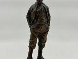 figurine en bronze représentant un garçon debout sur un socle en bois