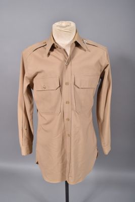 une chemise beige posée sur un mannequin, sur fond gris