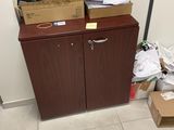 une armoire surmontée de boîtes, placée dans un coin de la pièce