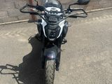 une moto garée sur un parking près d'un mur de briques
