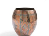 a copper vase with a geometric design on it