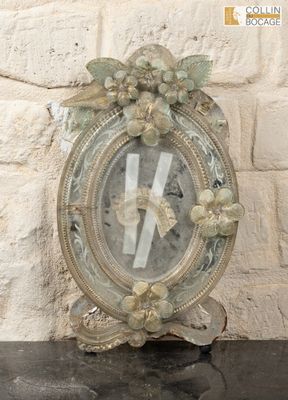 a clock that is sitting on a table in front of a brick wall