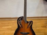 an acoustic guitar sitting on top of a hard wood floor next to a wall