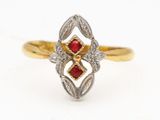 a close up of a gold ring with a red stone