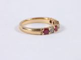 a close up of a gold ring with three ruby stones