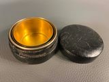 an image of a metal container with a gold lid on a table