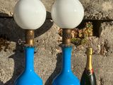 trois vases bleus et une bouteille de champagne posés sur une table