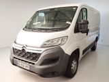 La camionnette blanche est garée dans une pièce blanche au sol blanc.