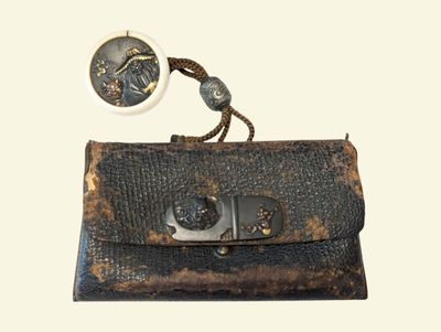un vieux sac à main muni d'un fermoir en métal et d'un bouton