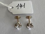 pair of 14k gold and diamond stud earrings with a price tag