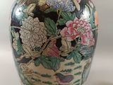a vase with flowers and birds on it next to a pair of shoes