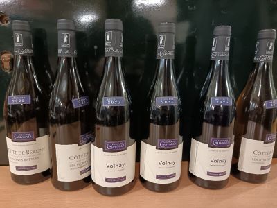 six bouteilles de vin sont alignées sur une table